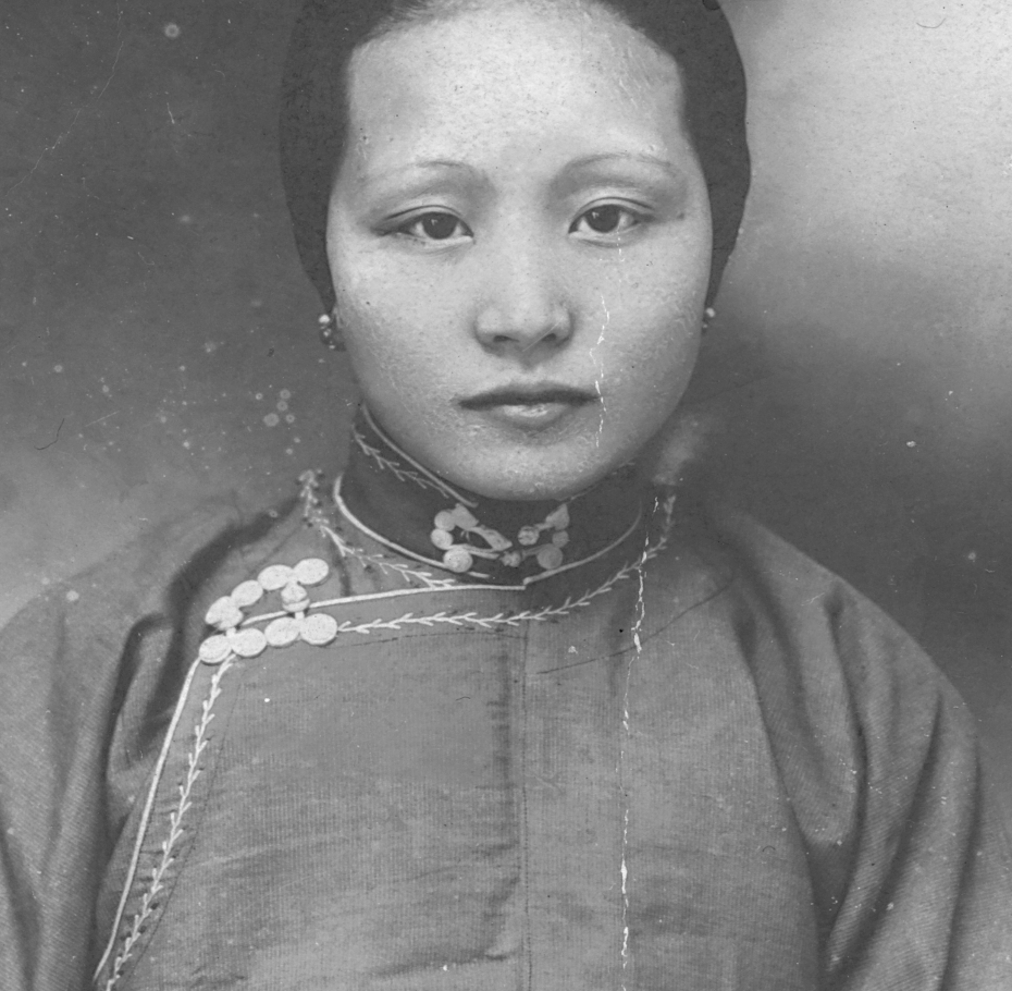 A black and white photograph of an Asian woman dressed in traditional garb.