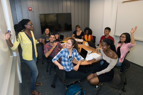 students with instructor at board