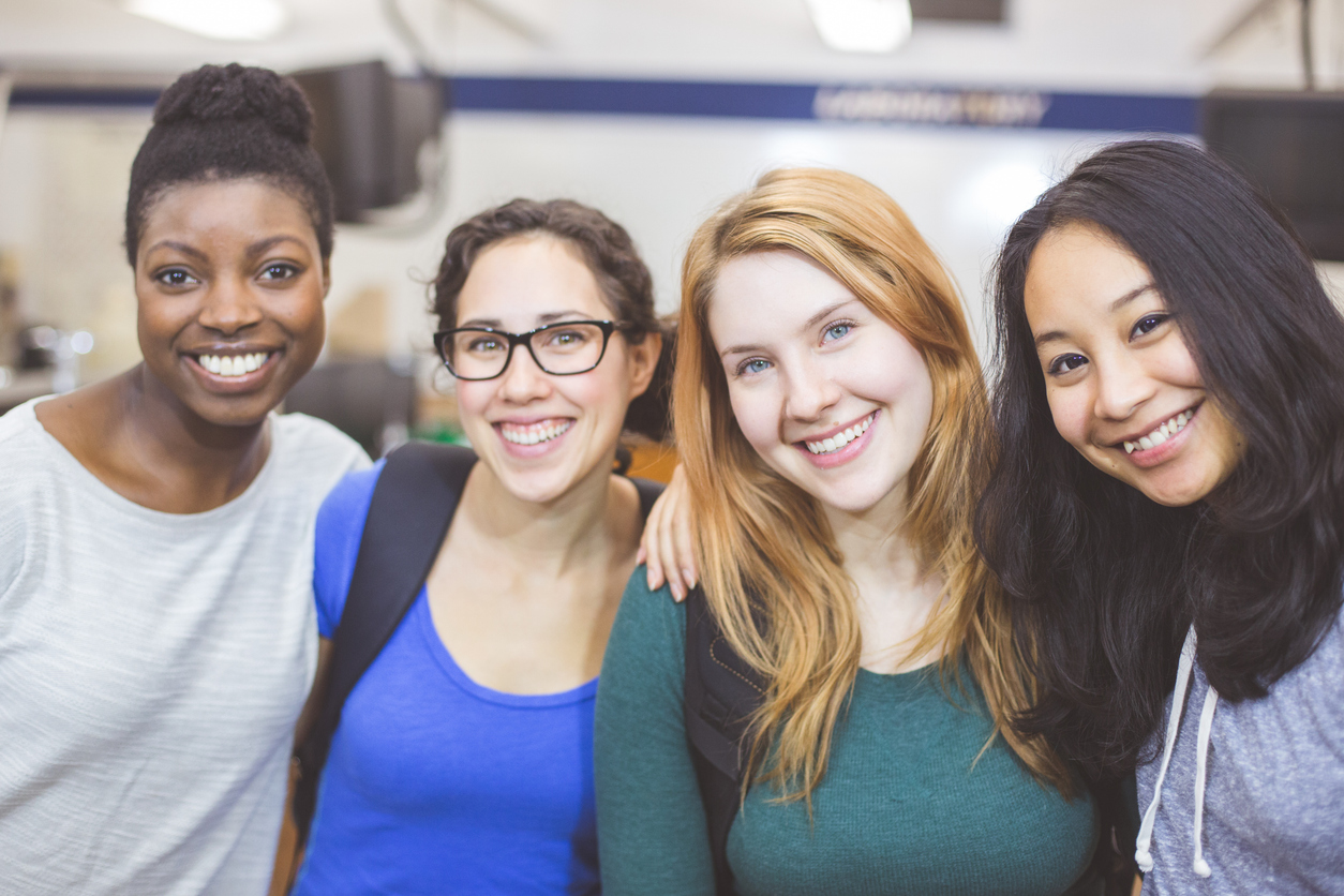 four young women, smiling